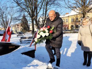 Starosta Jacek Bartkowiak i wicedyrektor ZSE Agnieszka Pol składają wiązankę kwiatów pod Pomnikiem Wolności.
